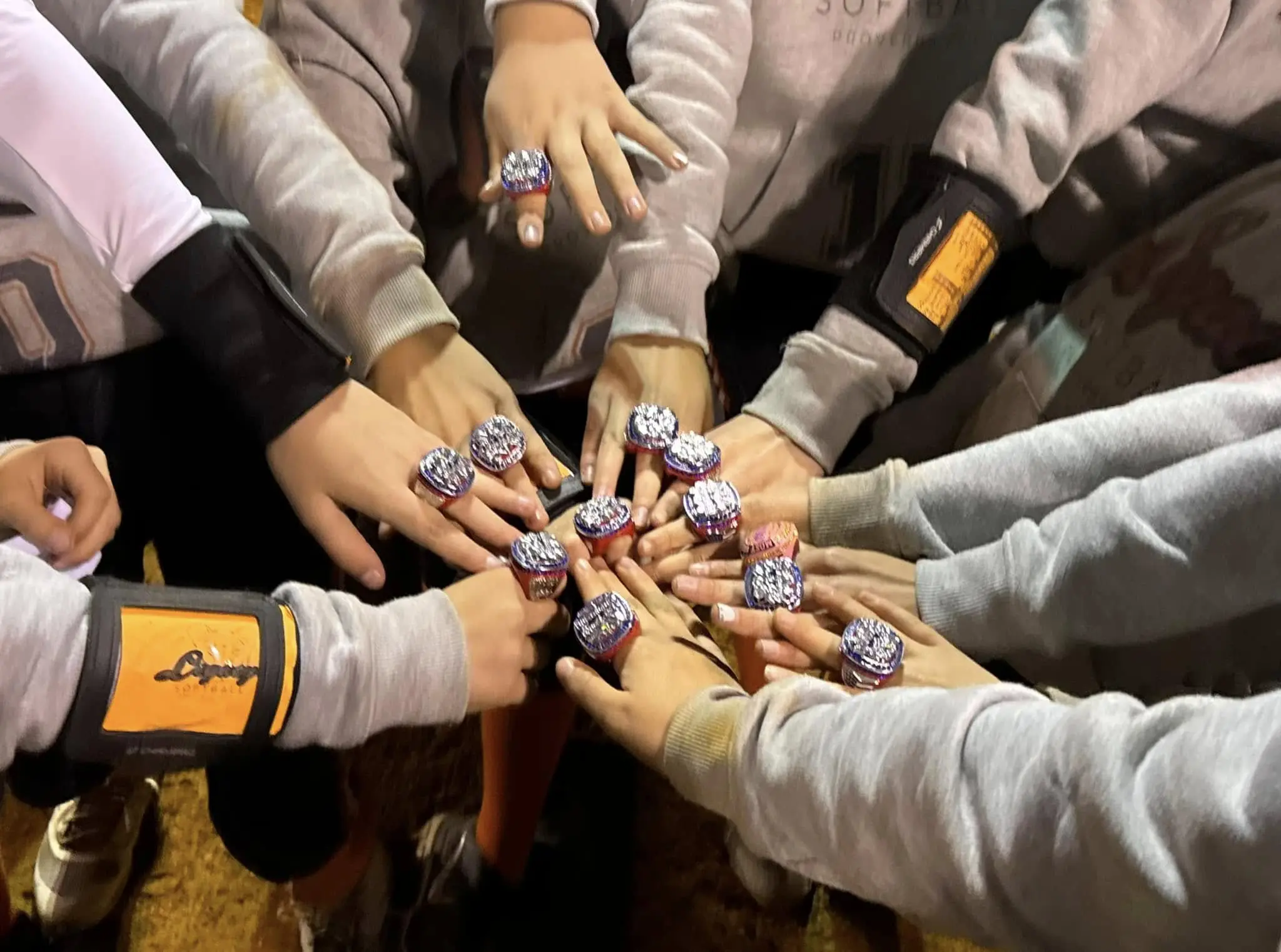 Hands wearing large sports rings together